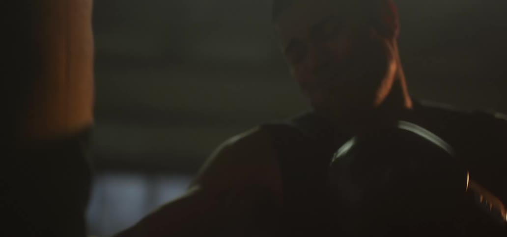 A boxer repeatedly hits a boxing bag while training in a gym
