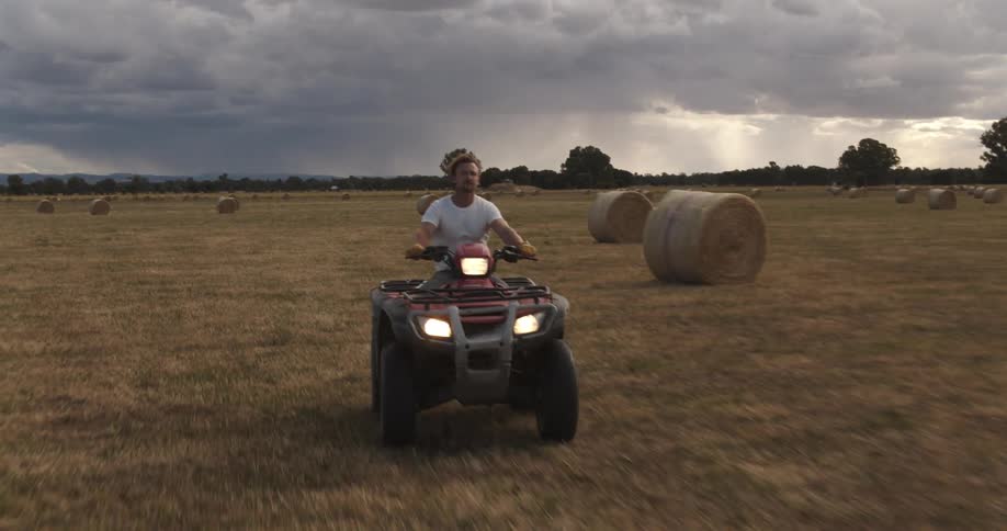 A man riding an atv on a farm