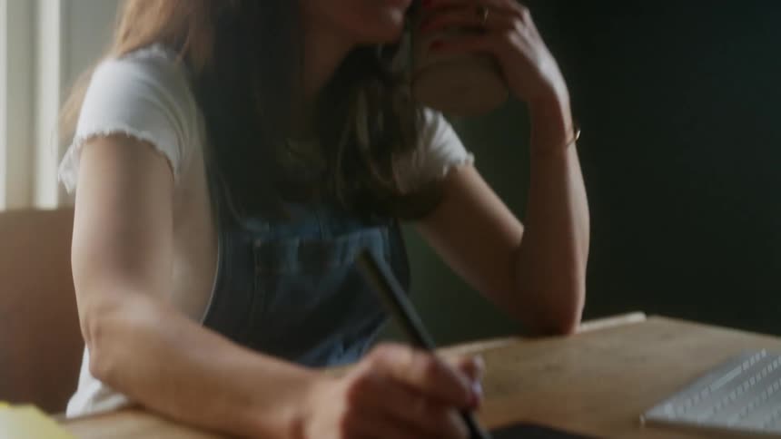 A woman using a drawing pad with a laptop