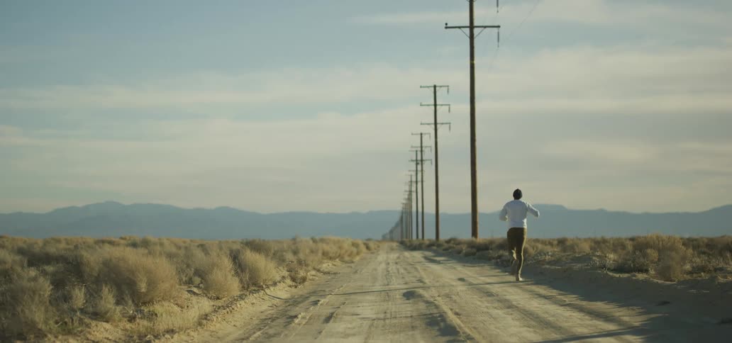 A man running down a road pumping his fist in the air