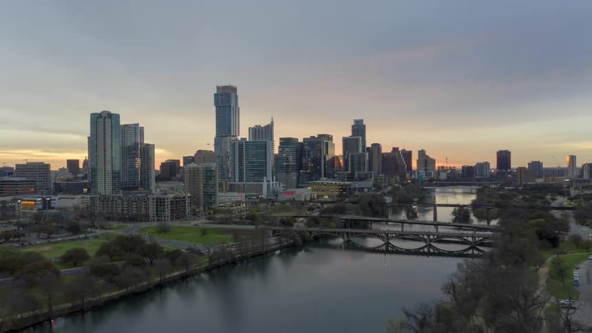 A time lapse of a city with skyscrapers vehicles driving and a river running through it
