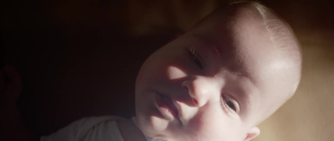 A baby is resting in bed