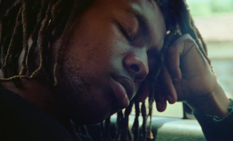 A man is resting in a moving car