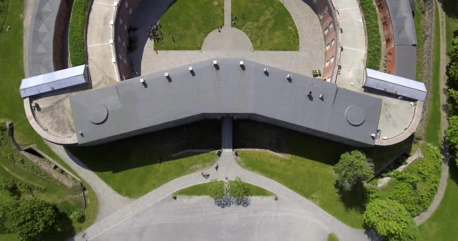 People walk around a large building