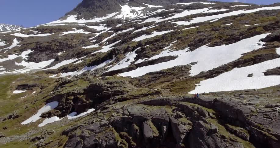 A rocky mountain covered in scattered snow