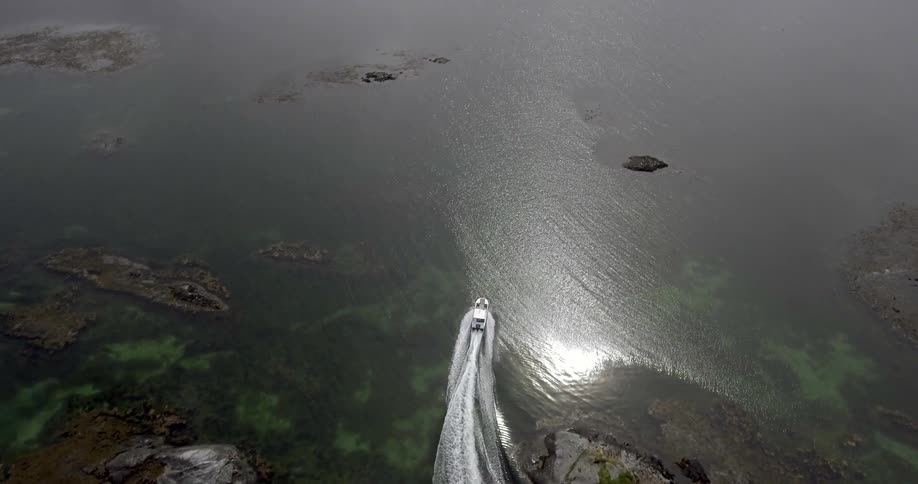 A boat navigates on a lake in the mountains