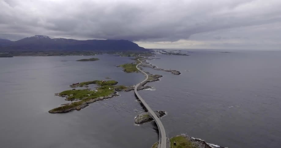 A long bridge over a large body of water on a cloudy day