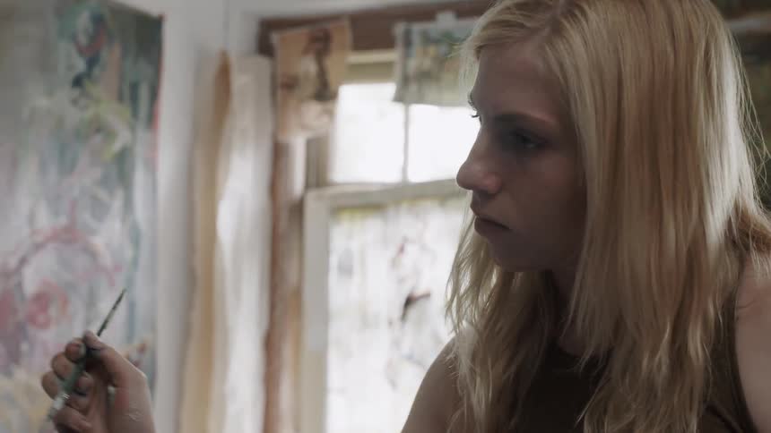 A blonde woman paints