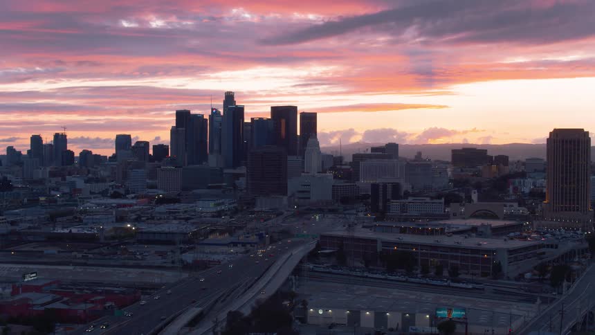 City skyline with colorful sky and busy traffic on the roads