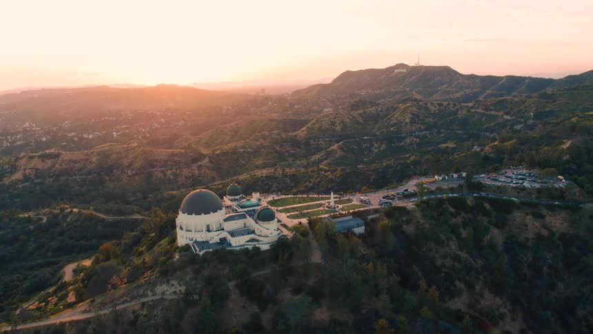 A large building around a mountain ridge in the countryside in the evening