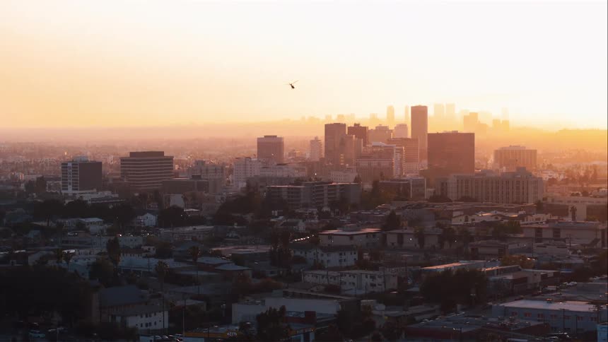 View of a city with surrounding neighborhoods with sun low in the sky