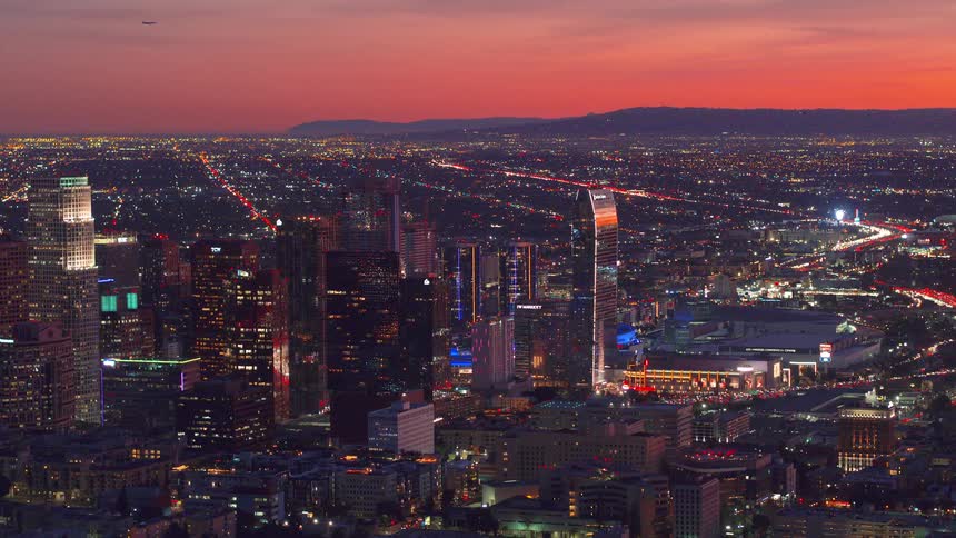 Citys downtown skyline lights under the red sunset sky