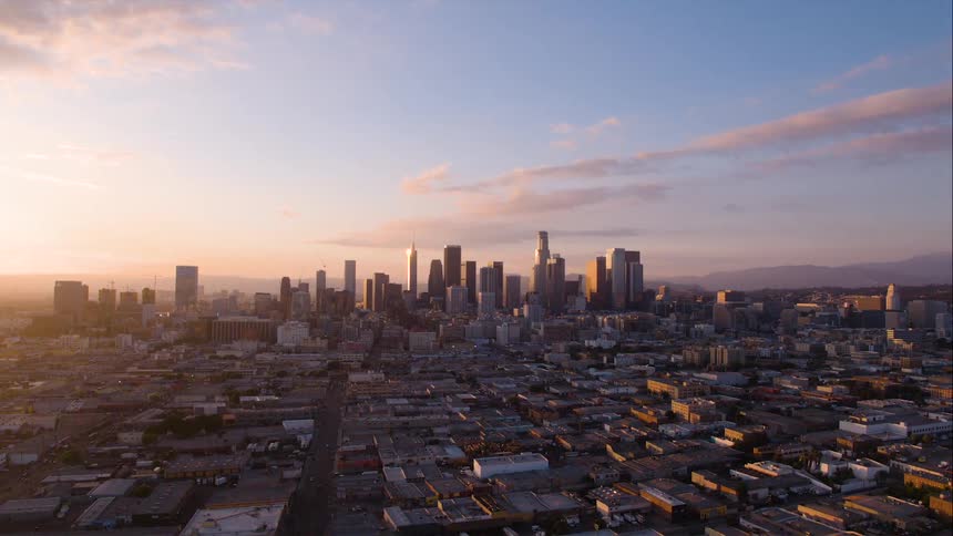 The skyscrapers of the center of a metropolis surrounding by smaller buildings at sunrise