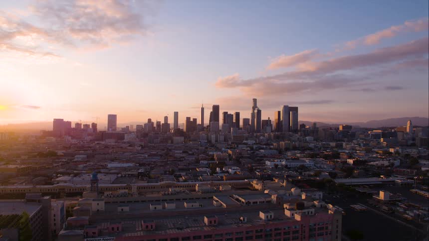 Sun rising over city with a few clouds in the sky
