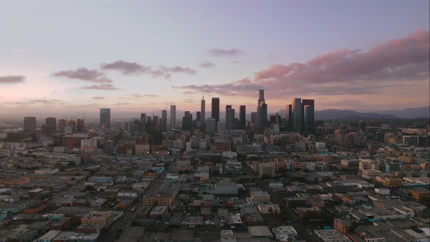 Aerial view of a city with high rise and skyscrapers in the distance in the evening
