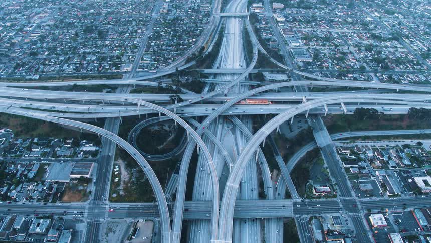Cars are driving on a complex freeway interchange near downtown Los Angeles