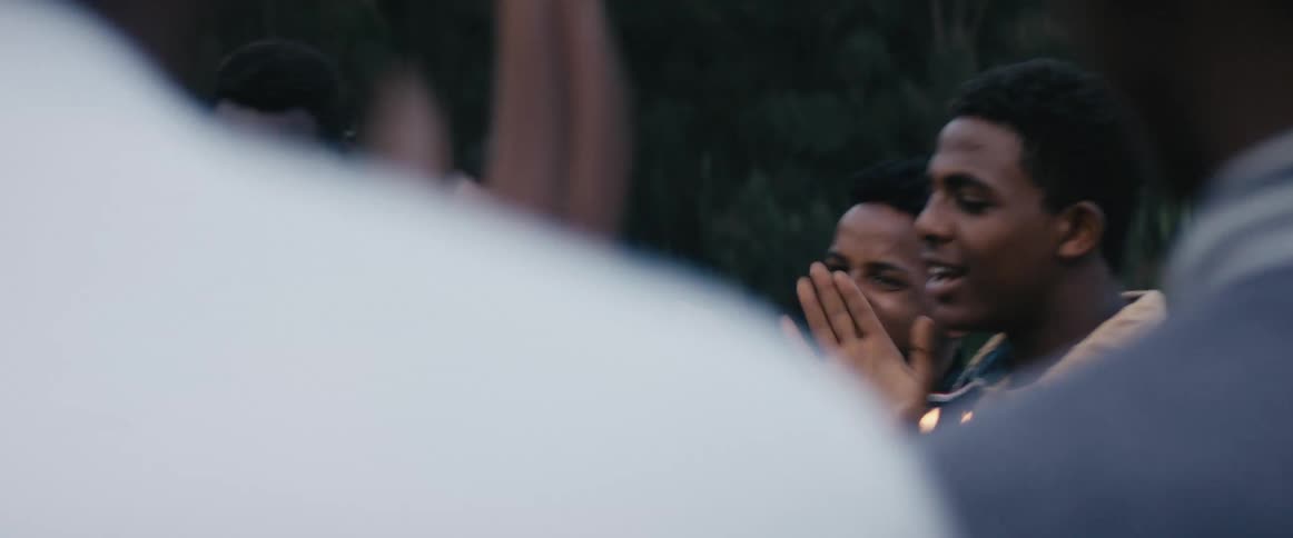 Group of friends clapping and dancing in a birthday outdoors in a field