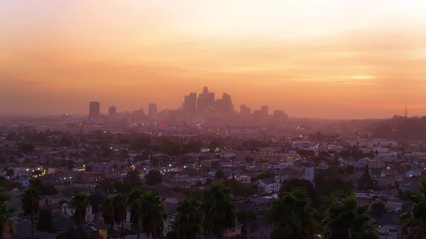 The sun is setting in a downtown city
