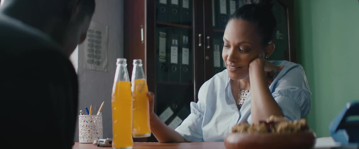 A woman drinks soda at the table