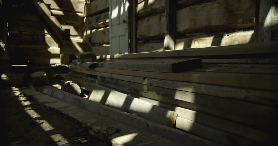 Inside a wooden cabin with sunlight and a door in the background