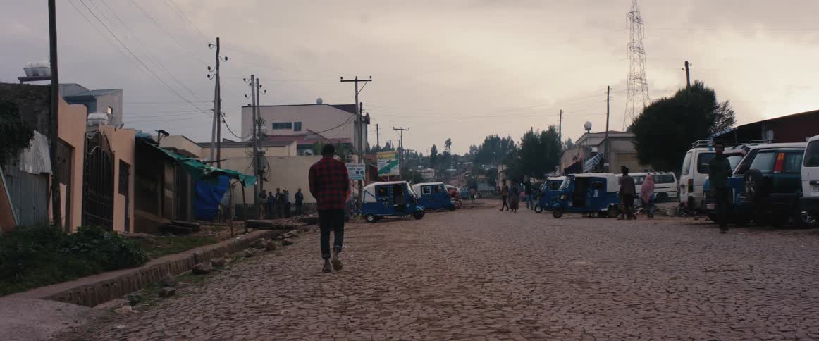 People walk around on a cobblestone street in a small village town at daytime