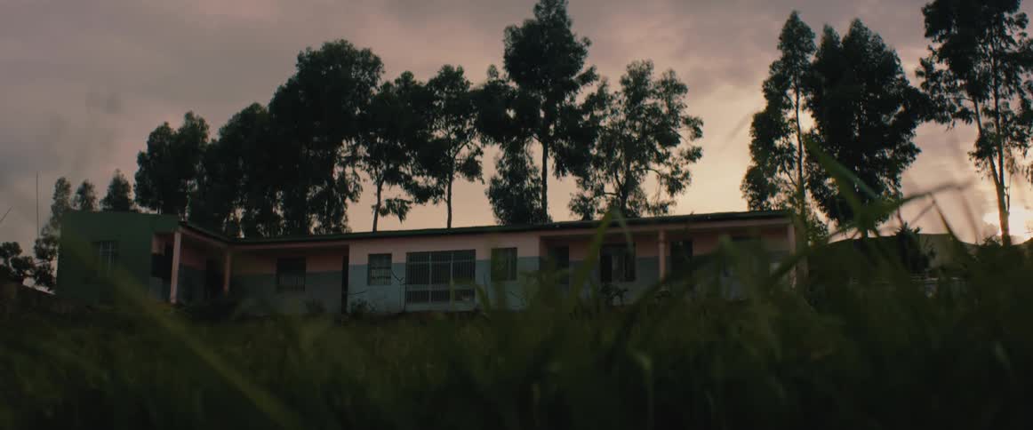 Exterior of a house at dusk surrounded by trees