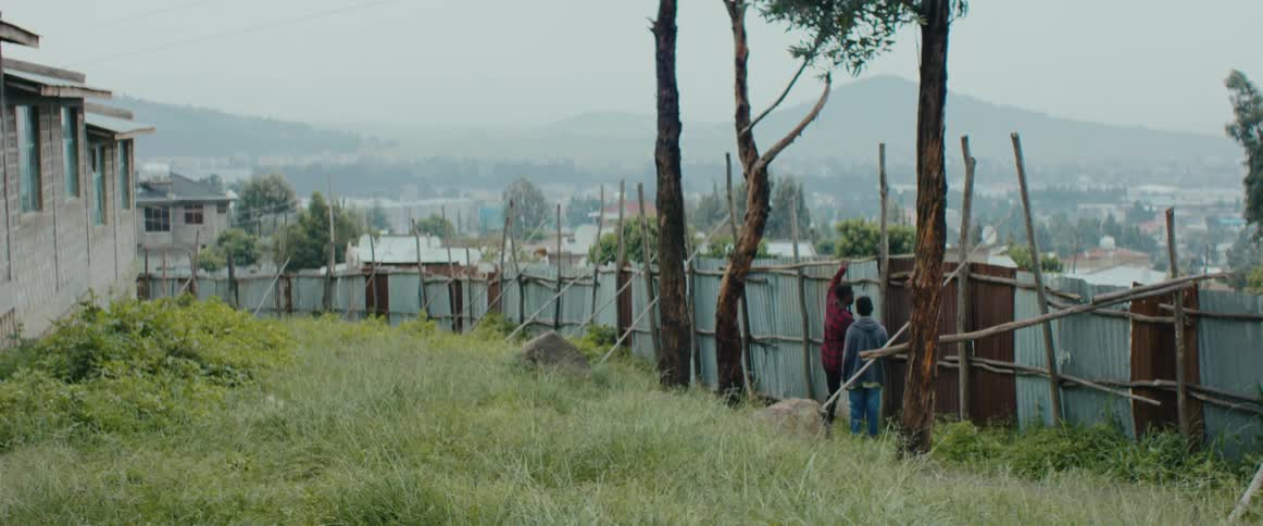 2 children jumping a fence
