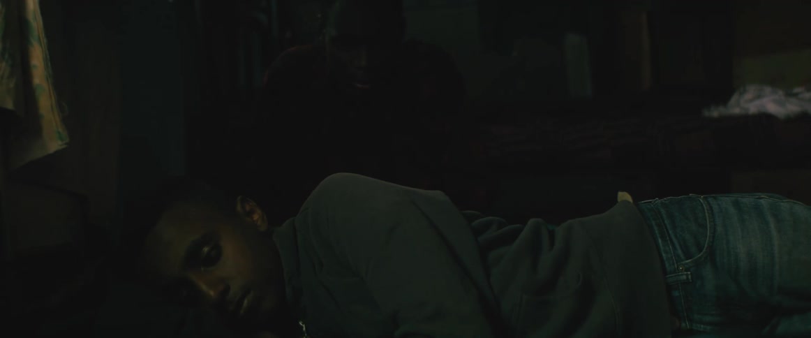 Man walks into room sitting down next to boy lying down on bed