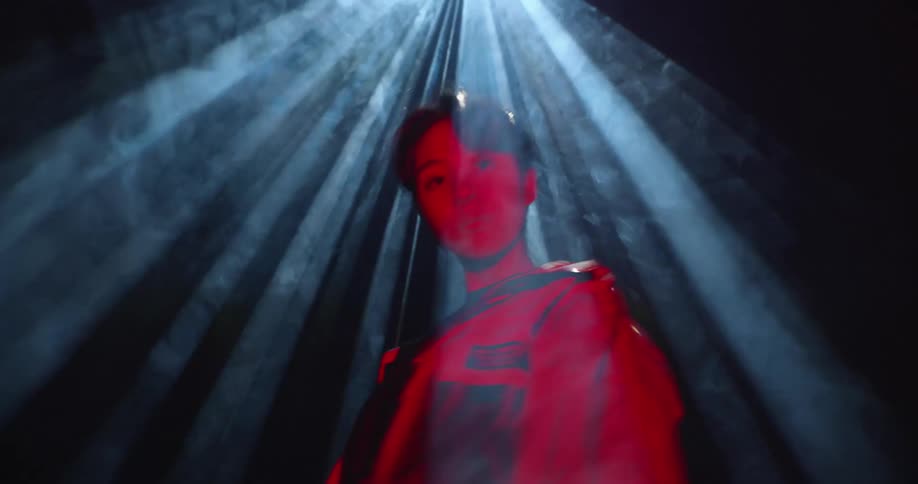A man standing and dancing under a light