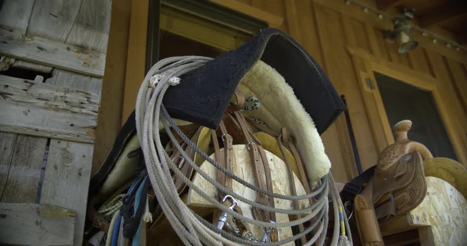 Rope is rolled up and placed on top of a saddle stand at a log cabin