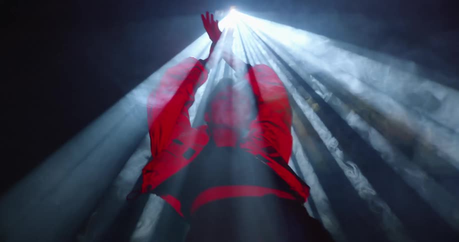 A woman is dancing under a spotlight