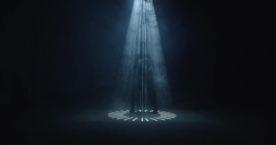 A performer stands under a spotlight
