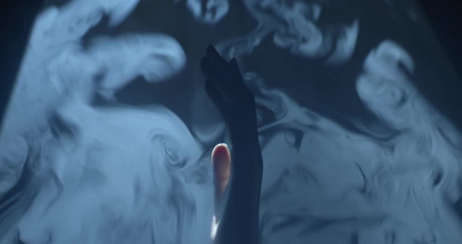 A hand reaching out from a layer of fog