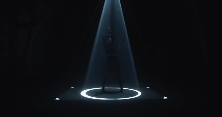Person stands in ring of spotlight that grows and then shrinks