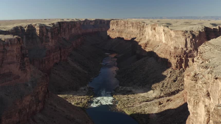 The sun is shining on a valley between cliffs