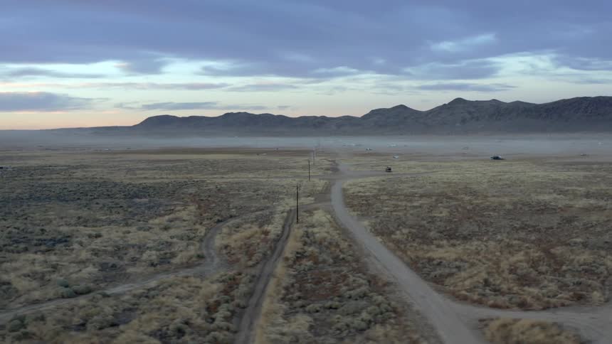 Rural area with dirt roads and mountains and a cloudy sky