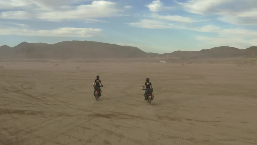 Drone shot of motorcycle riders riding across the desert