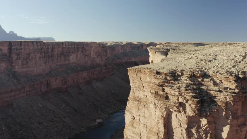 Mesa river canyon escarpment with mountains on the horizon on a clear day