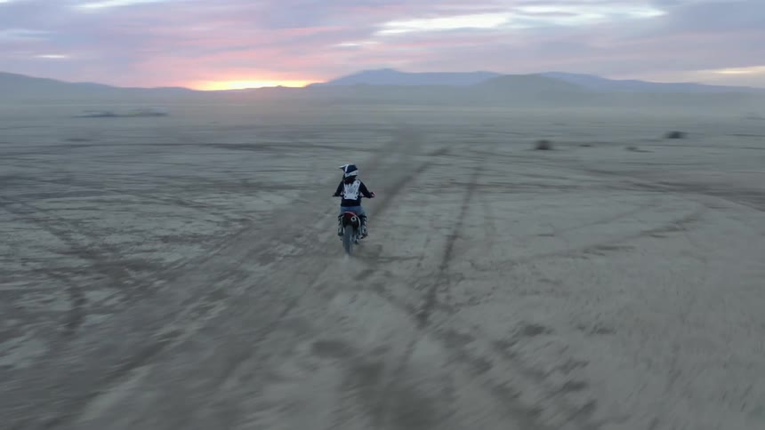A man dirtbiking in a desert