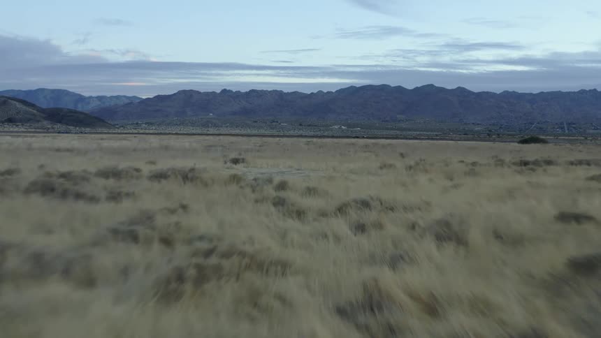 A grassy field with hills in the distance