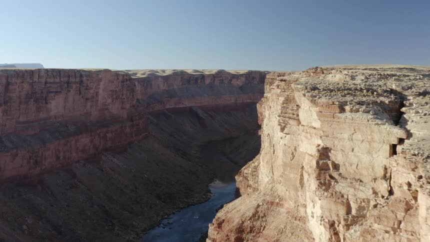 Aerial view of a river running inside a canyon through a mesa in the badlands