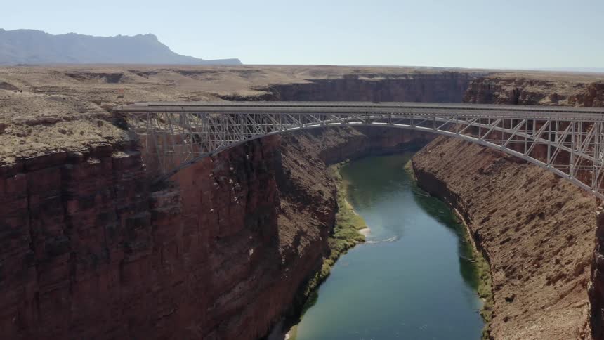 An aerial view of a bridge over a canyon with a river below