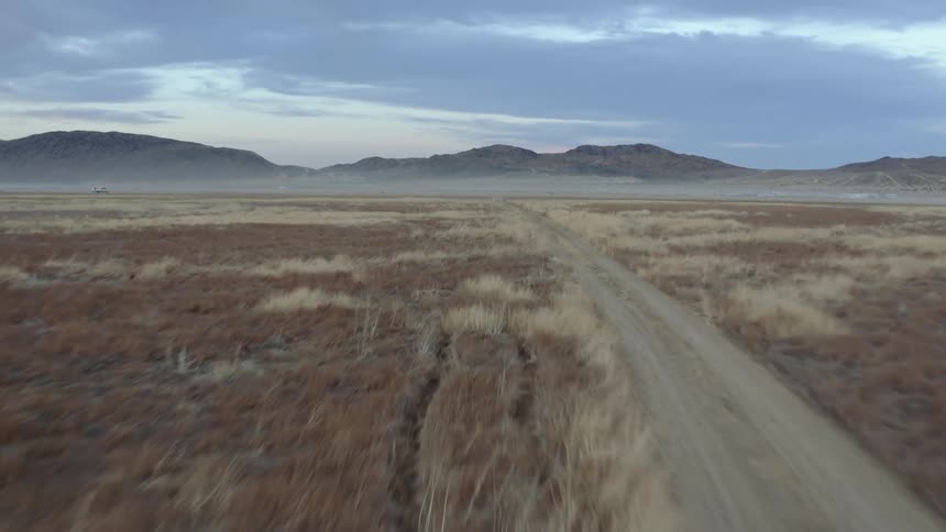 Aerial view of the dirt roads on the plains near the mountains at morning