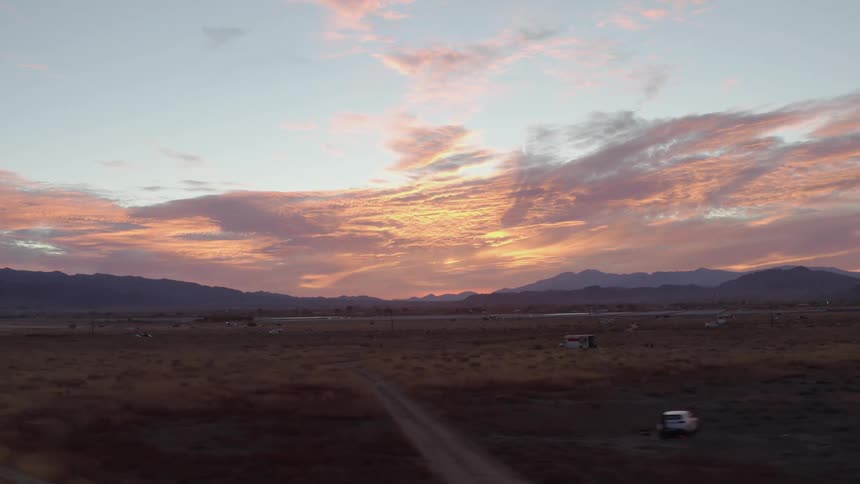 The fields are barren besides a few vehicles