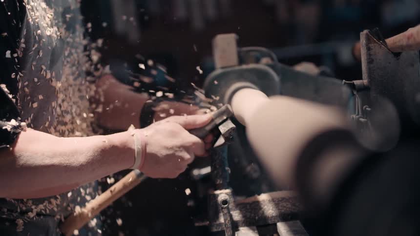 A man is shaving wood on a machine
