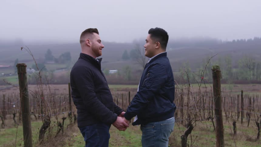Couple holding hands in a farmland setting