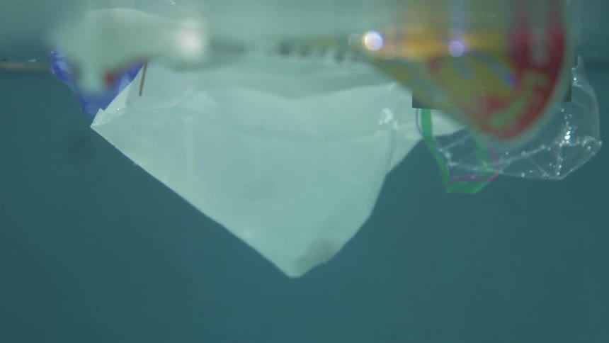 Garbage consisting on plastic bottles and bags floating on the surface of the water
