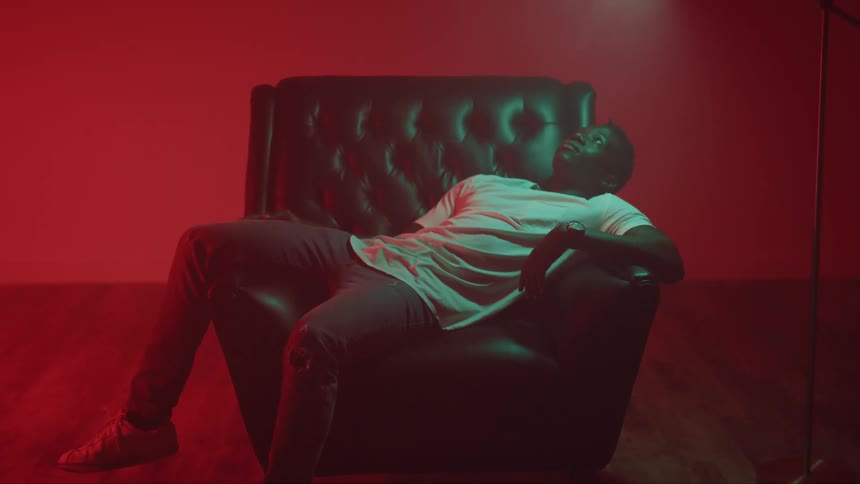 A man sitting in a wide chair