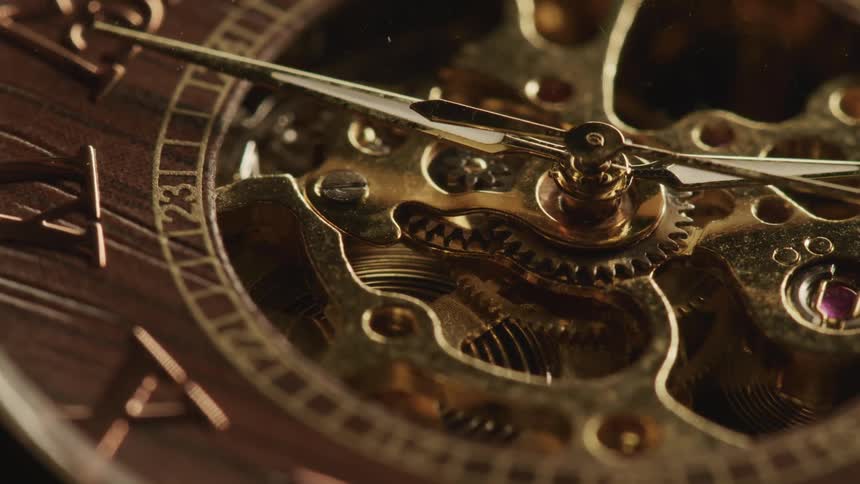 A closeup of the face of an elaborate mechanical pocket watch reveals its incredible craftsmanship