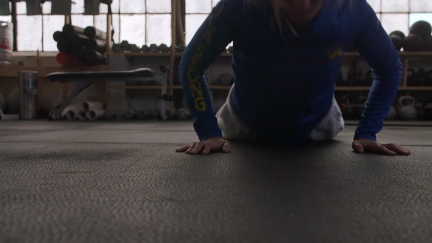 A female athlete does a series of exercises in a gym